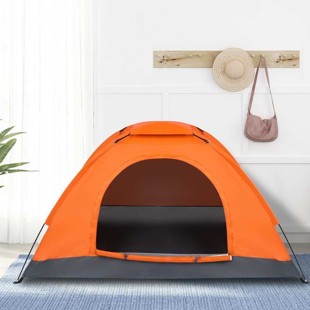 Lightweight orange 1-person waterproof camping dome tent set up outdoors for backpacking