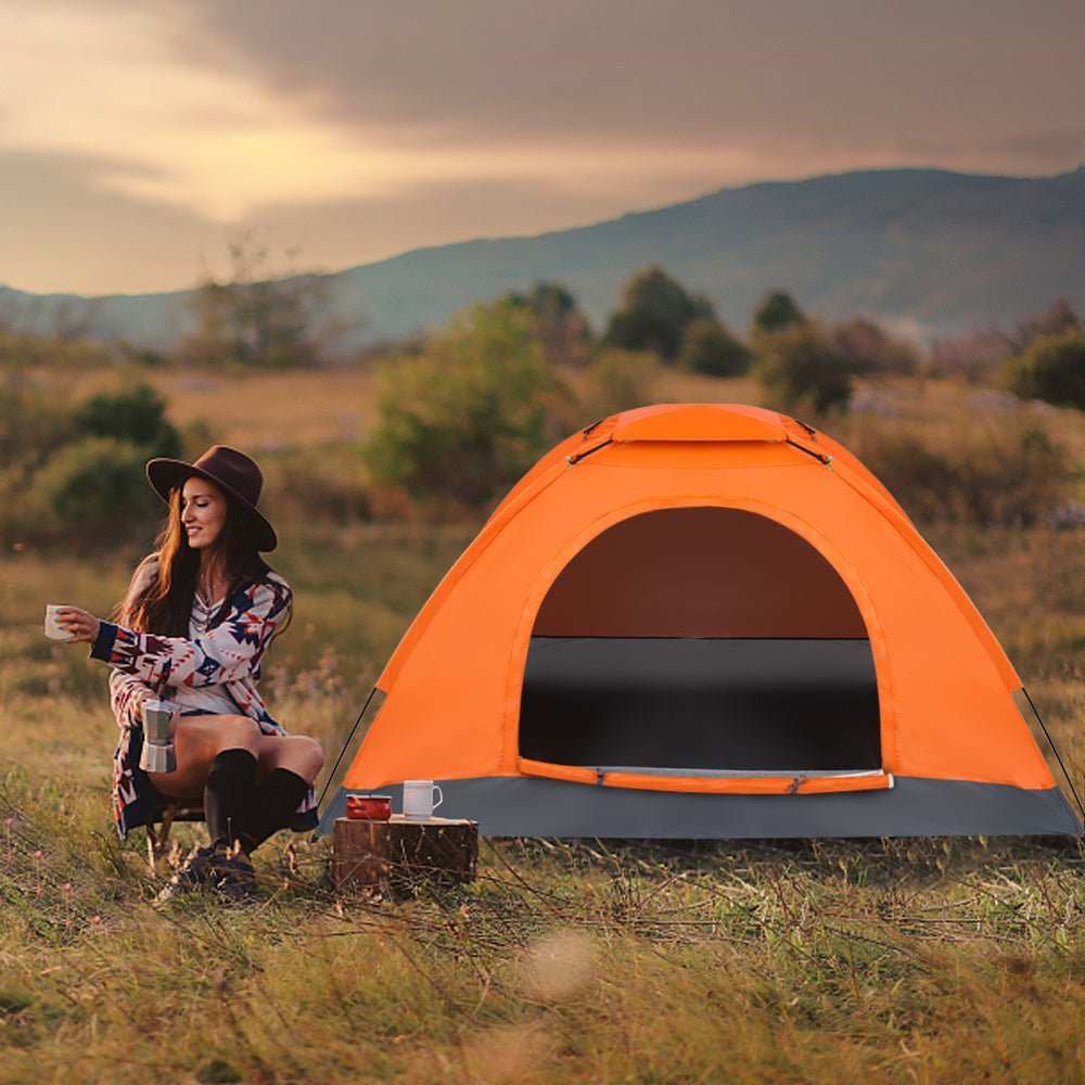 Lightweight orange waterproof camping dome tent set up outdoors for backpacking