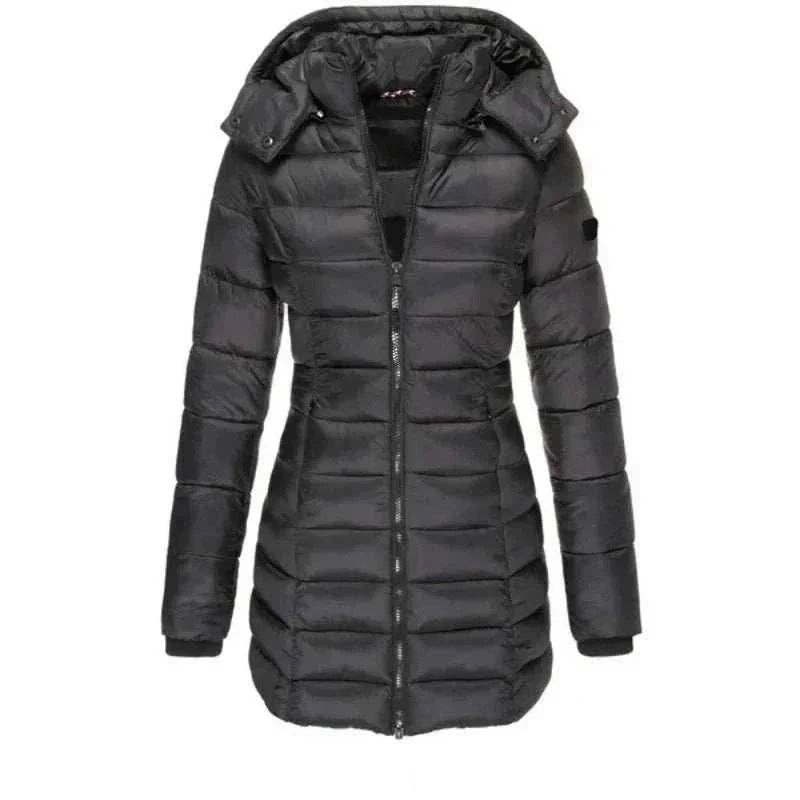 Woman wearing a mid-length hooded padded winter parka with full-zip and pockets, standing outdoors