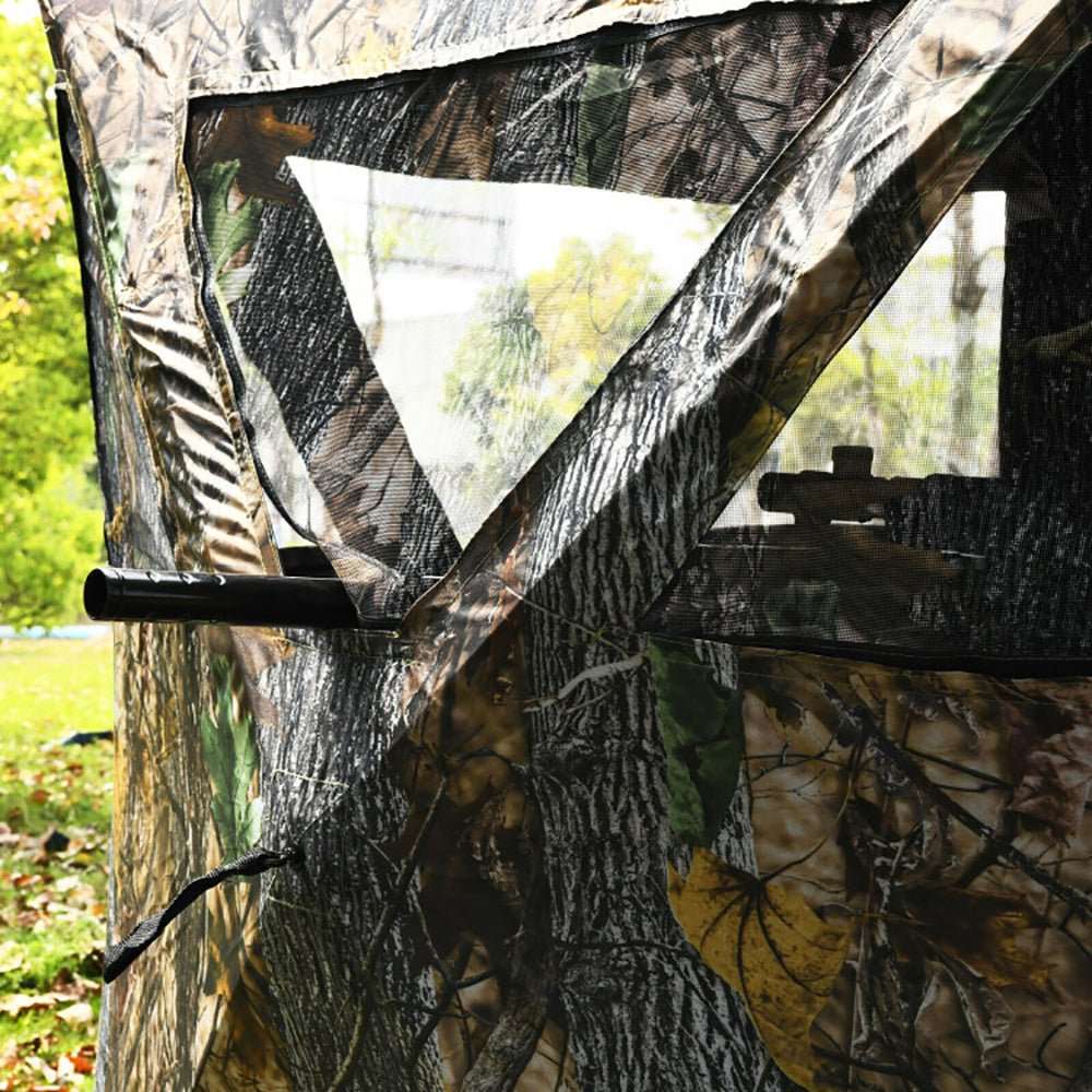 Portable pop up ground hunting blind with camouflage, mesh windows, and tie downs for quick setup and concealment.